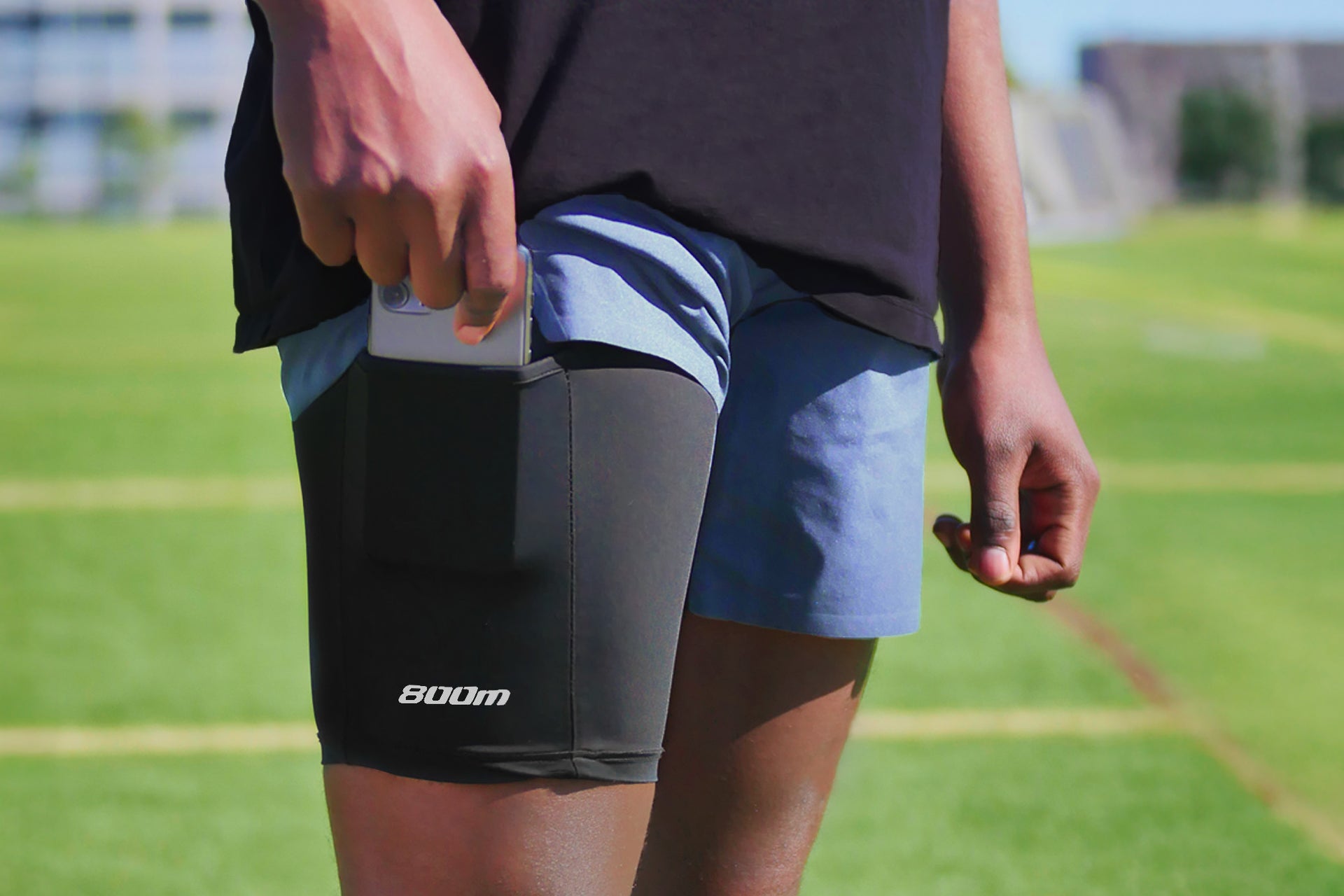 A picture of a man standing in a field and grabbing a smartphone out the legband sold by 800m.