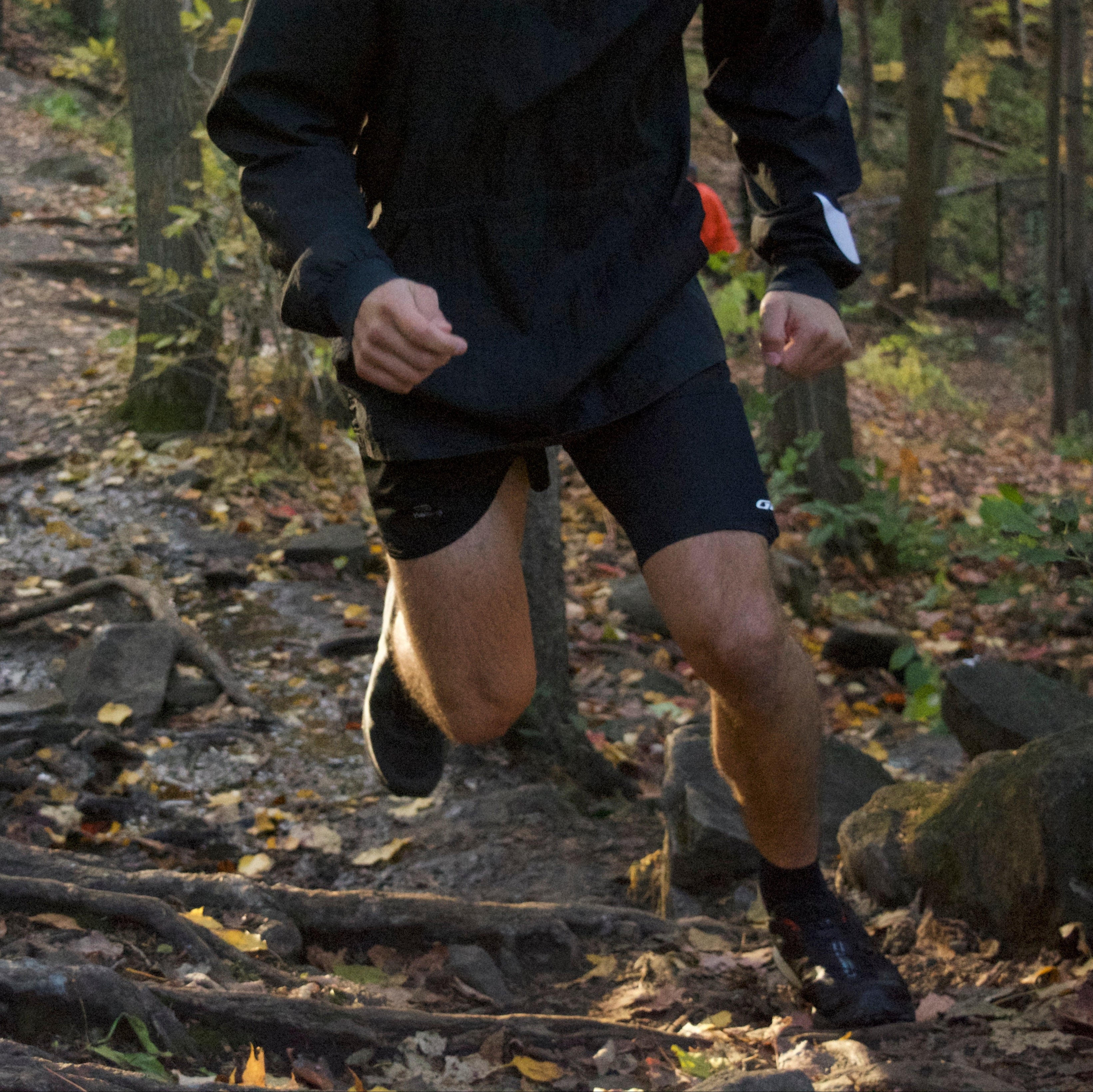 A picture of a man trail running while wearing the legband sold by 800m.